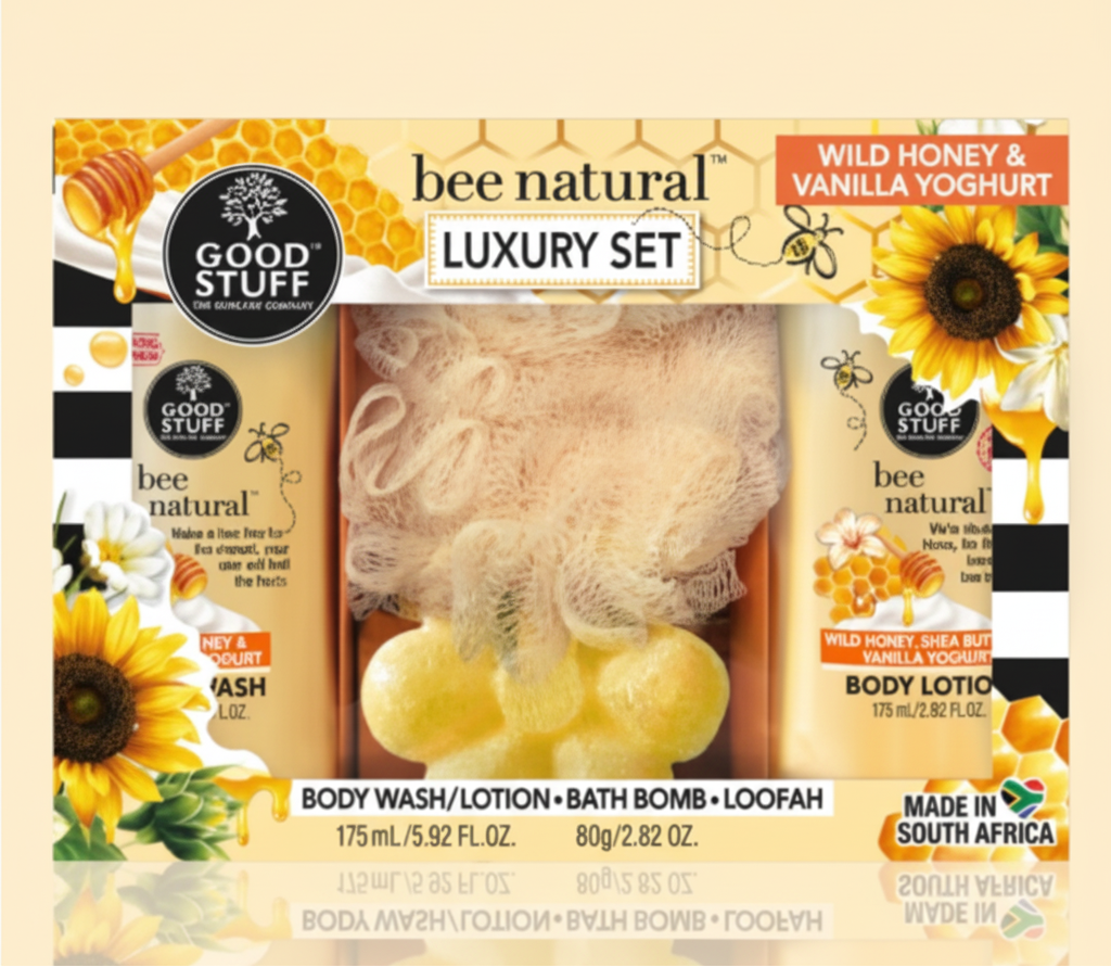 Bee Natural luxury set with body wash, lotion, bath bomb and loofah on a light beige background.